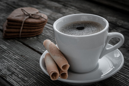 White cup of coffee on a natural old wooden background with biscuits. Selective focus. With copy spaceの写真素材