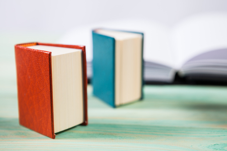 Pile of miniature books on wooden background. With copy space for your textの写真素材