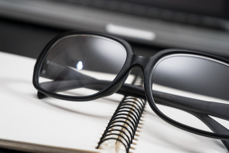 Black framed glasses on the computer keyboard with a very shallow depth of field. Copy space for textの写真素材