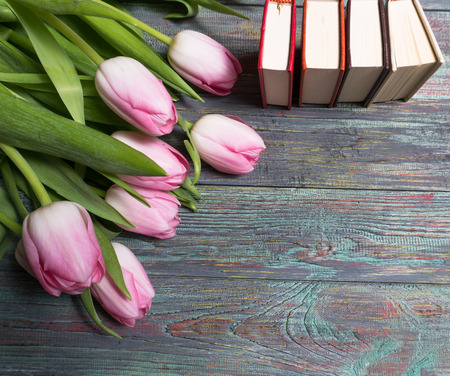 Pink tulips with books on wooden background with copy spaceの写真素材