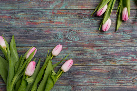 Border from bright pink tulips flowers on wooden background. Selective focus, place for textの写真素材