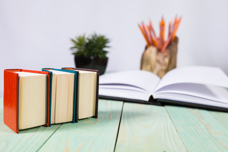 Pile of miniature books on wooden background. With copy space for your textの写真素材