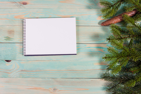 Christmas background with spruce branches on wooden board with notebook copy spaceの写真素材