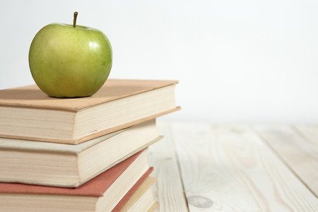 Stack of books and apple on the table. Copy space for text. Selective focus. Knowledge conceptの写真素材
