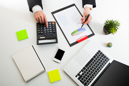 Close up view of bookkeeper or financial inspector hands making report, calculating or checking balance. Marketing strategy brainstorming. Paperwork and digital in office.の写真素材