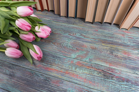 Pink tulips with books on wooden background with copy spaceの写真素材