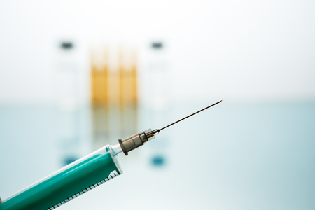 Medical Vaccine vial hypodermic injection treatment disease care in hospital and prevention illness. against a background of medical bottles with injection, drug or vitaminの写真素材