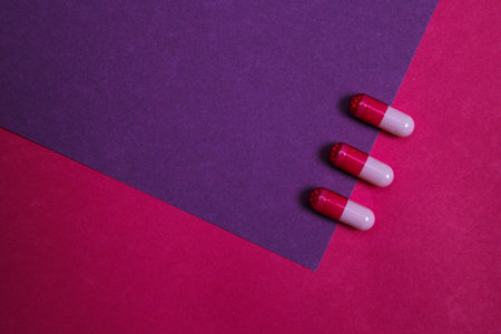 Assortment of various colourful pills on pastel coloured background. Medication and prescription...