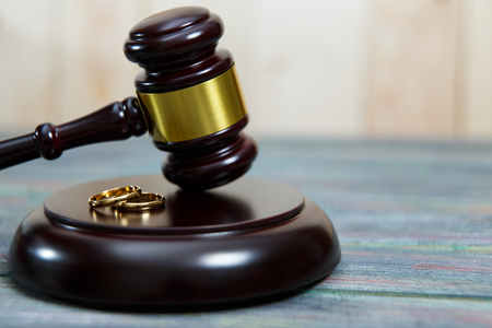 Closeup of wedding rings on wooden mallet at table in courtroomの写真素材
