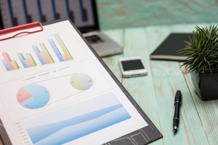 Business Desktop. Photo diagrams graphs and numerals in the table on the paper