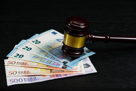 Judge's gavel on the background of euro bills on wooden backgroundの写真素材