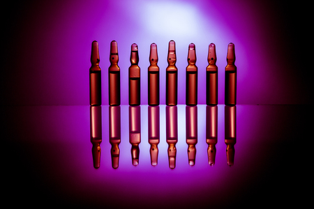 Group object of liquid medicinal agent in limpid glassware in medical laboratory. Ampoules with cosmetical tools, collagen or vitaminsの写真素材