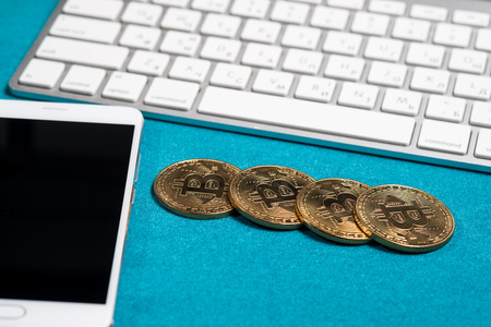 Golden bitcoins on a top, and smart phone and laptop. Bitcoin cryptocurrency. Miner with dollars from trading. Digital currency. Profit from mining cryptocurrencies.の写真素材