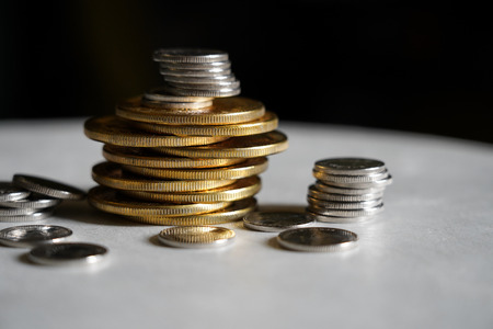 Macro shot detail of golden and silver color coin stacks on dark background with copy space for text. Business and finance growth, saving money, investment and interest concept. selective focusの写真素材