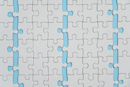 Missing jigsaw puzzle pieces. Business concept. Fragment of a folded white jigsaw puzzle and a pile...