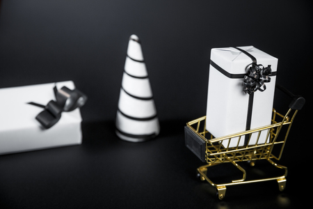 White Christmas tree and gift in shop cart isolated on black background. Copy Space For Advertisement.の写真素材
