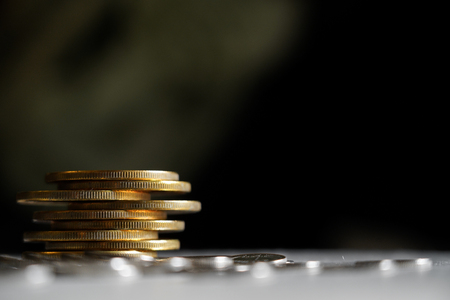 Macro shot detail of golden and silver color coin stacks on dark background with copy space for text. Business and finance growth, saving money, investment and interest concept. selective focusの写真素材