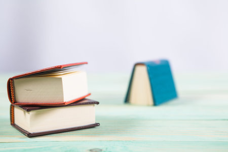 Pile of miniature books on wooden background. With copy space for your text