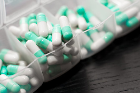 Extreme close up of seven day pill box with pills. Blu pill-box with tuesday pills visible. Open...
