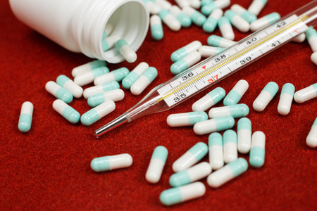 Assorted pharmaceutical medicine pills, tablets and capsules over red background