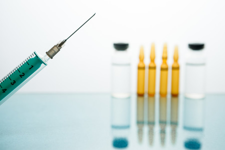 Medical Vaccine vial hypodermic injection treatment disease care in hospital and prevention illness. against a background of medical bottles with injection, drug or vitaminの写真素材