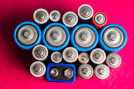 Ecology recycling concept. Many different types used or new battery, rechargeable accumulator, alkaline batteries on color background. Nature energyの写真素材