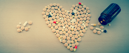 Colorful drug pills in shape of heart/pharmaceutical concept/toned photo/Top viewの写真素材
