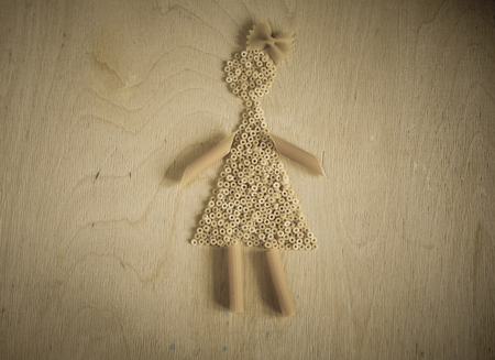 Pasta on a old Chalkboard forming a girl. Raw pasta background.の写真素材