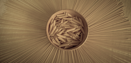 Spaghetti, farfalle, fusilli on forming a sun. Composition of uncooked italian pasta.   Raw pasta background.の写真素材