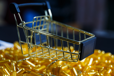 Cart shop assortment of various colourful pills on pastel coloured background. Medication and prescription pills background.の写真素材