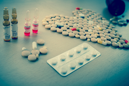 Colorful drug pills in shape of heart. pharmaceutical concept. toned photoの写真素材