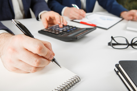 Business people discussing the charts and graphs showing the results of their successful teamworkの写真素材