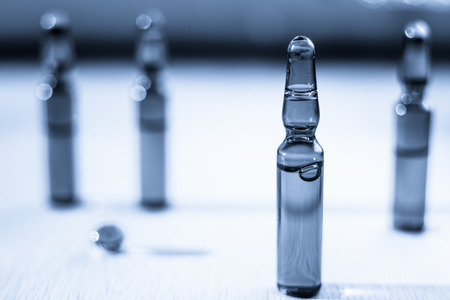 Scattered tablets, pills, ampoules for injection on wooden background. Health care concept.の写真素材