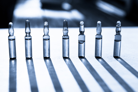 Group object of liquid medicinal agent in limpid glassware in medical laboratory. Ampoules with cosmetical tools, collagen or vitaminsの写真素材
