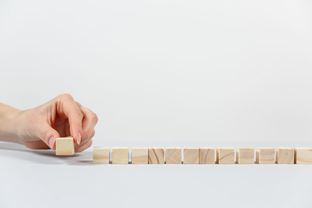 Closeup of businessman making a pyramid with empty wooden cubes. Concept of business hierarchy.