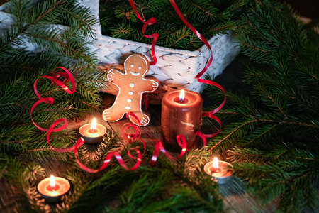A gingerbread man with Christmas decorations and lots of fir branches. Christmas gift box. Holiday greeting card. Copy spase, spase for text.の写真素材