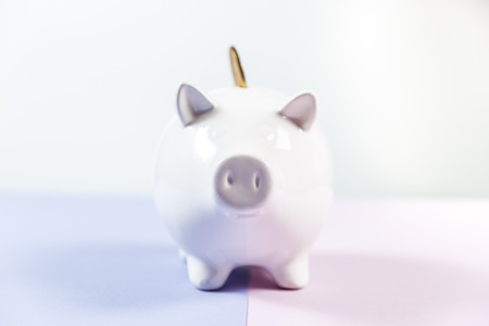 Piggy bank with growth coins against blank backgroundの写真素材