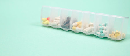 Assorted medical drugs and syringe on blue background, with copy space