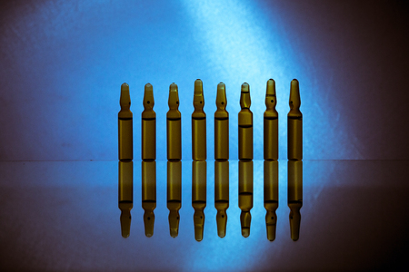 Group object of liquid medicinal agent in limpid glassware in medical laboratory. Ampoules with cosmetical tools, collagen or vitaminsの写真素材