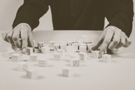 Closeup of businessman making a pyramid with empty wooden cubes. Concept of business hierarchy.