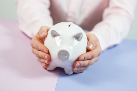 Woman's hands with piggy bank closeup. Selective focus. Piggy Bank, Savings, Currency.の写真素材