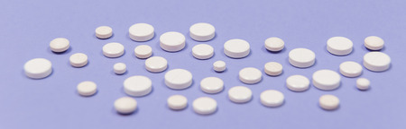 White pill on a purple background with copy space. Antibiotics drug resistance. Antimicrobial capsule pills. Pharmaceutical industry. Pharmacy.の写真素材