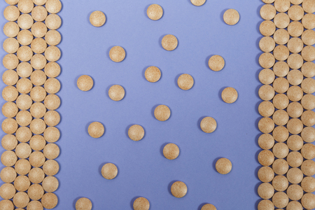 Many brown pills on a purple background with copy spaceの写真素材