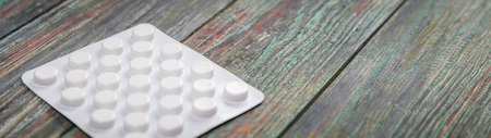 White pill on a wooden background with copy space. Global healthcare concept. Pharmaceutical industry. Pharmacy.の写真素材