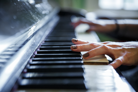 Closeup of antique piano keys and wood grain. musician hands playing piano on piano keyboard.low key tone image. abstract musical background.の写真素材