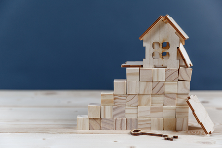 Real estate concept. Small toy wooden house with keys with copy spaceの写真素材