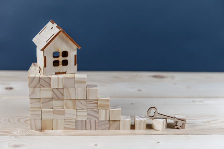 Real estate concept. Small toy wooden house with keys with copy spaceの写真素材