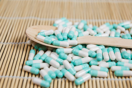 Alternative medicine tablets on a wooden spoon with a copy of space