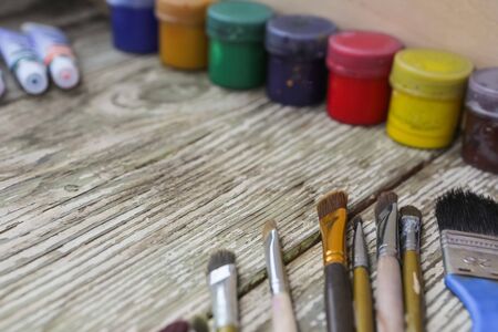 Different colorful brushes on the table, wooden background. Clean painter workplace ready for drawing.の写真素材