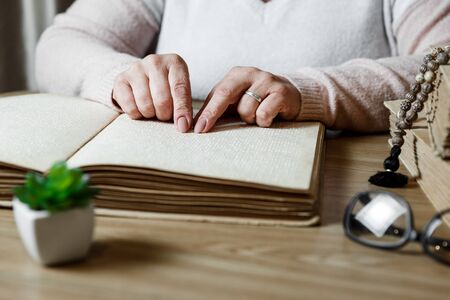 close up view of woman reading braille text on old bookの写真素材